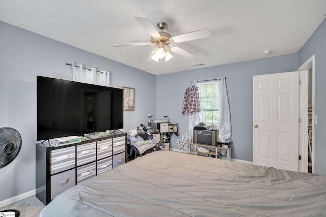 bedroom featuring a textured ceiling, carpet floors, and ceiling fan