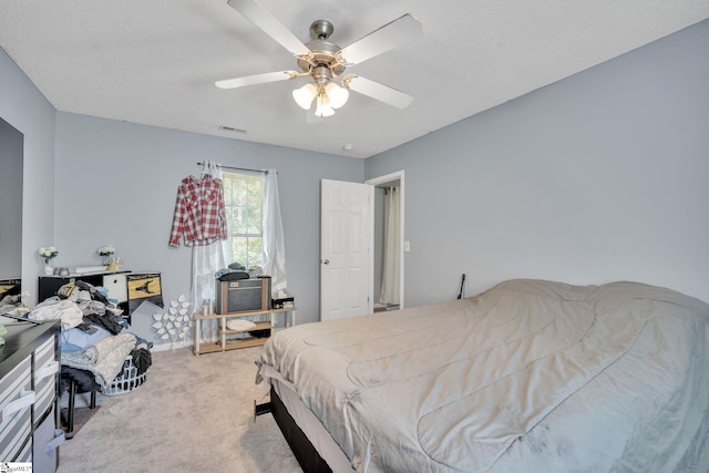 carpeted bedroom with a textured ceiling and ceiling fan