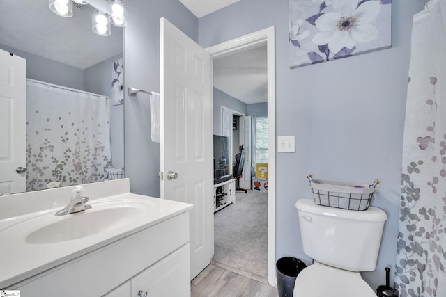 bathroom with vanity, a shower with shower curtain, hardwood / wood-style flooring, and toilet