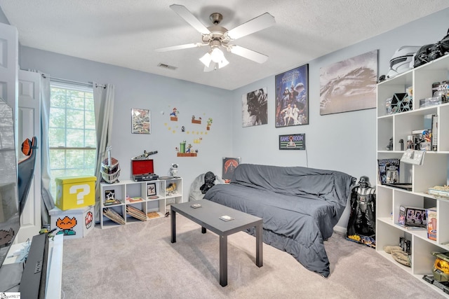 bedroom featuring ceiling fan, carpet, and a textured ceiling