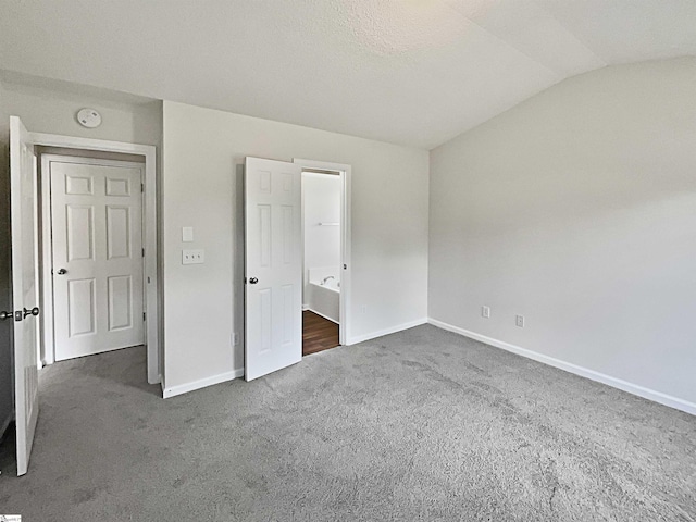 unfurnished bedroom featuring dark carpet, vaulted ceiling, a textured ceiling, and a closet