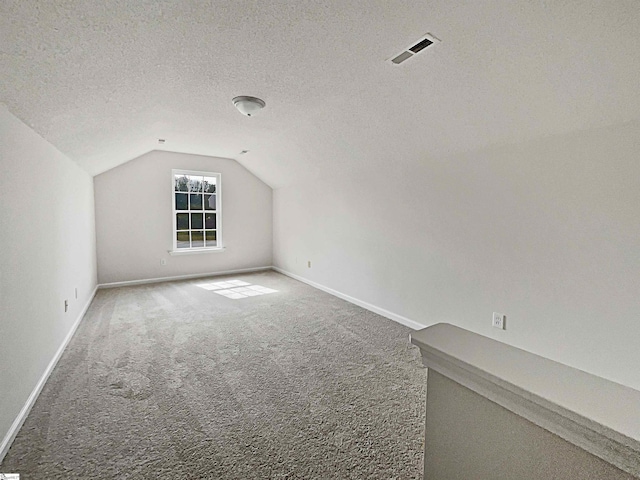 bonus room featuring a textured ceiling, carpet, and vaulted ceiling