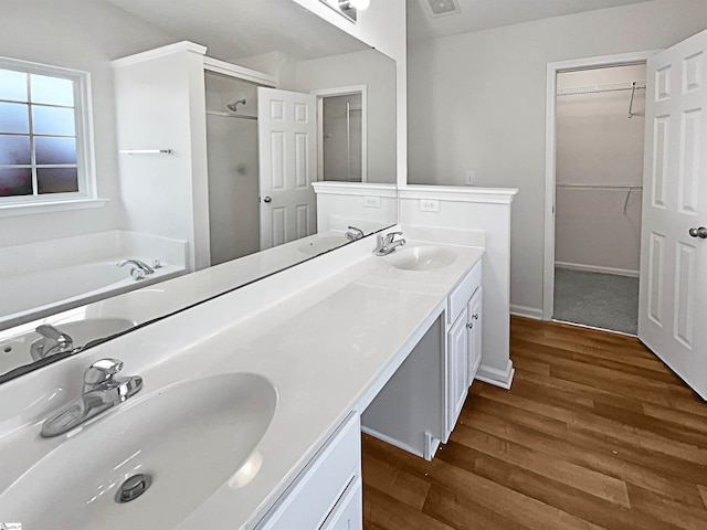 bathroom featuring vanity, plus walk in shower, and wood-type flooring