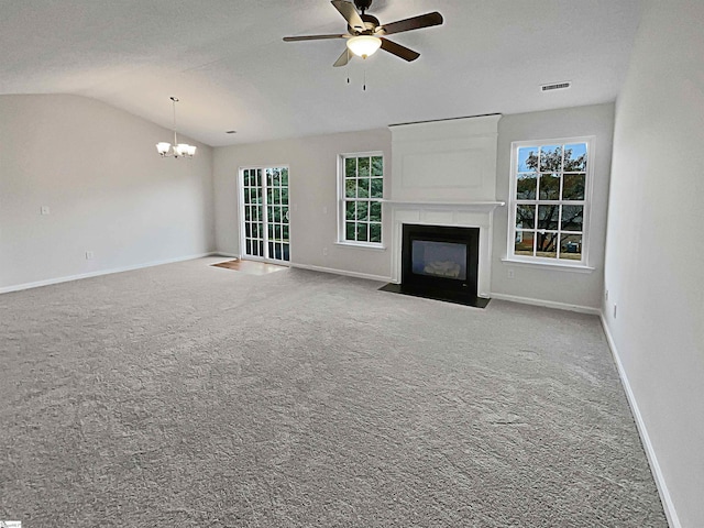 unfurnished living room featuring lofted ceiling, carpet flooring, a large fireplace, and ceiling fan with notable chandelier