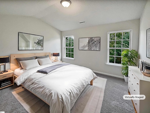 carpeted bedroom featuring vaulted ceiling and multiple windows