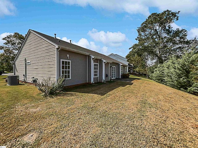 view of side of property featuring a lawn and central AC unit