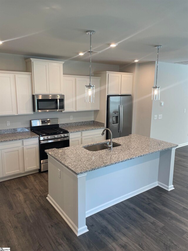 kitchen featuring dark wood-type flooring, pendant lighting, sink, and stainless steel appliances