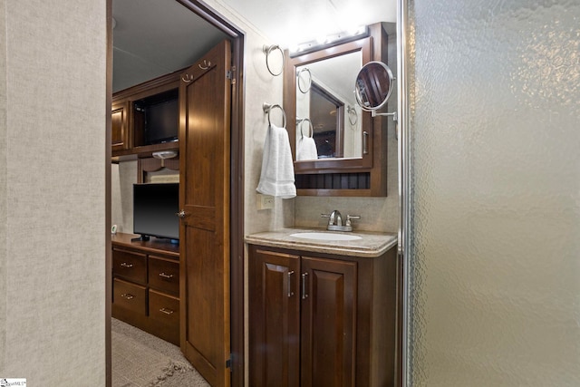 bathroom with a shower with door and vanity