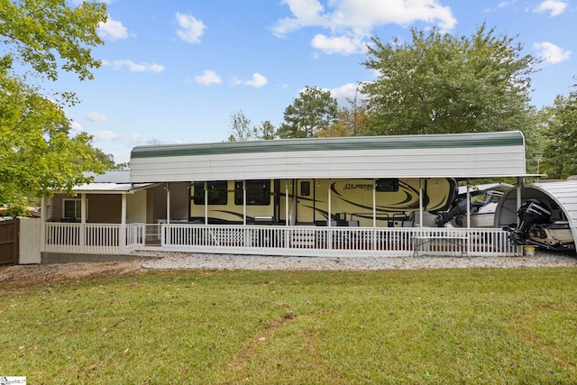 back of house with covered porch, a lawn, and a carport