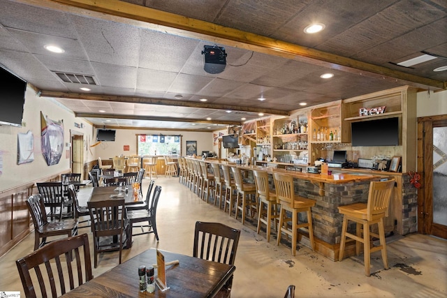 dining room featuring a drop ceiling and bar