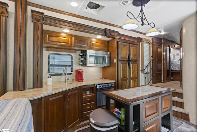 kitchen with hanging light fixtures, black oven, crown molding, and a kitchen island