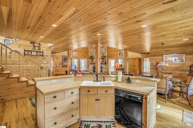 kitchen with sink, light hardwood / wood-style flooring, wood walls, and dishwasher