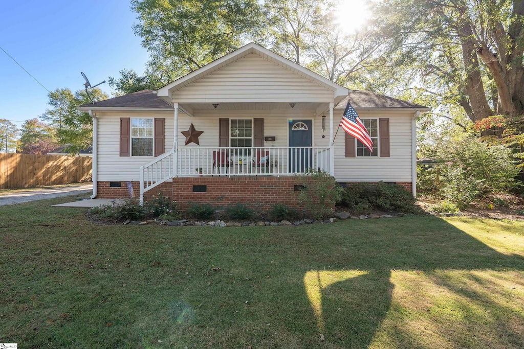 bungalow with covered porch and a front lawn