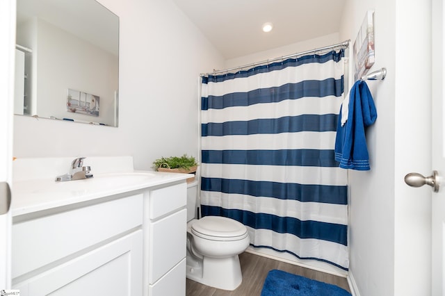 bathroom with vanity, toilet, hardwood / wood-style flooring, and walk in shower