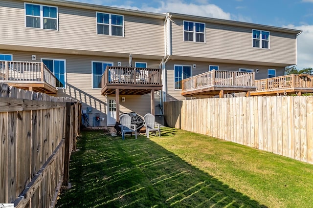 rear view of house featuring a deck and a lawn