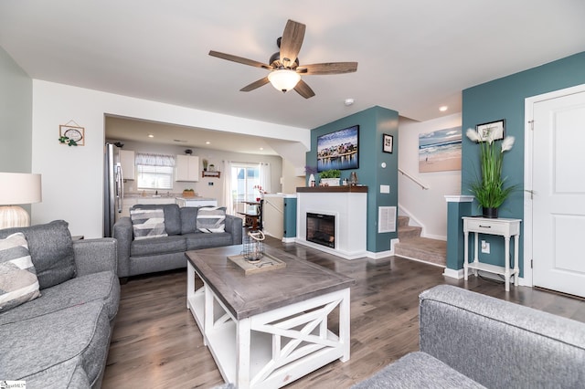 living room with dark hardwood / wood-style floors and ceiling fan