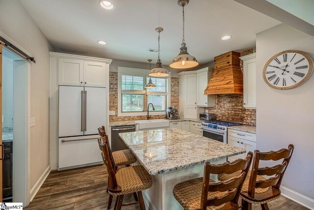 kitchen featuring high end appliances, sink, custom exhaust hood, white cabinets, and dark hardwood / wood-style flooring