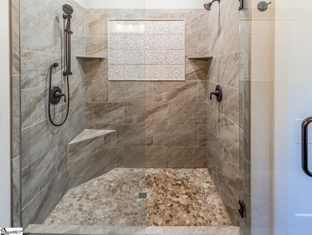 bathroom with a shower with door