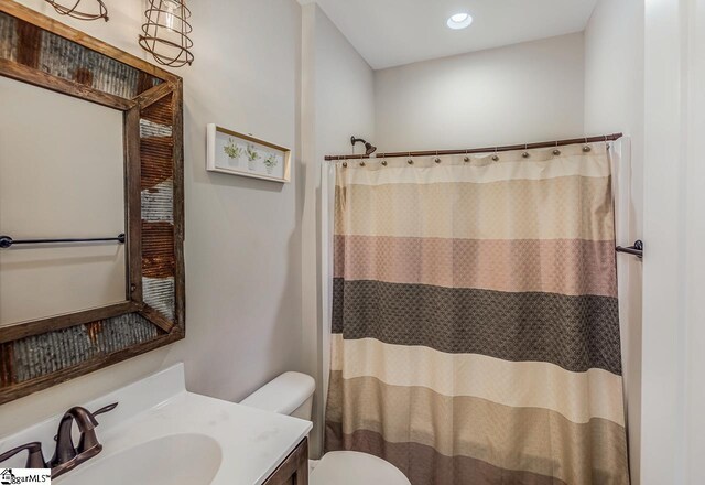 bathroom with vanity, curtained shower, and toilet