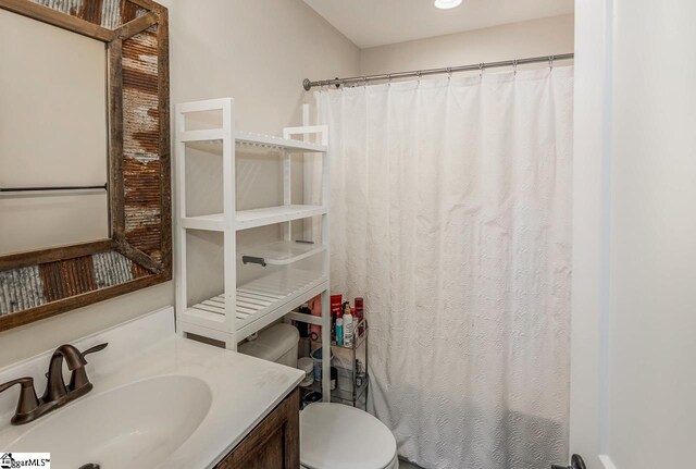 bathroom featuring vanity, toilet, and a shower with shower curtain