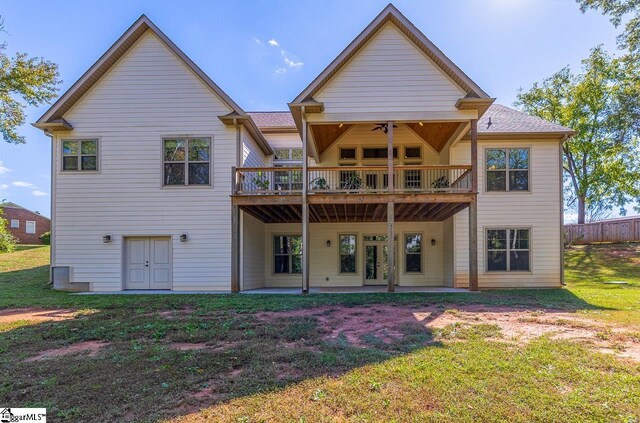 back of property with a yard and ceiling fan