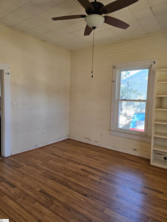 unfurnished room featuring dark wood-type flooring and ceiling fan