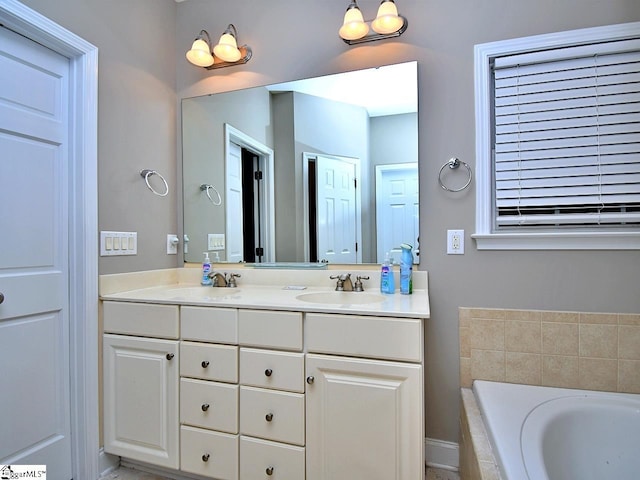 bathroom with vanity and a relaxing tiled tub