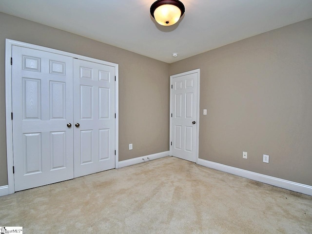 unfurnished bedroom featuring a closet and light carpet