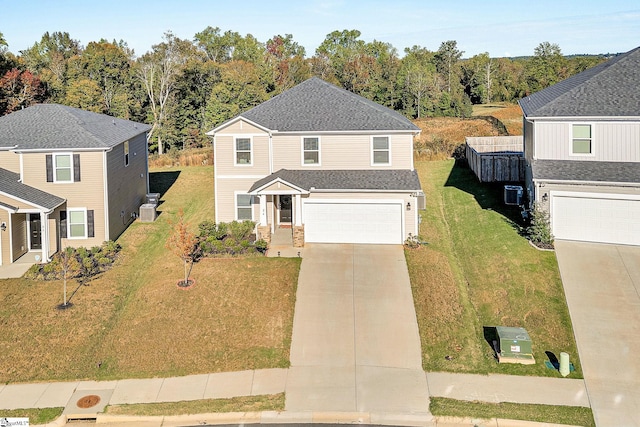 front of property featuring a garage, a front lawn, and central AC unit