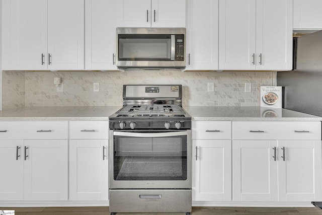 26 Shorncliffe Rd, Simpsonville, SC 29680 - kitchen featuring light stone counters, tasteful backsplash, white cabinetry, and stainless steel appliances