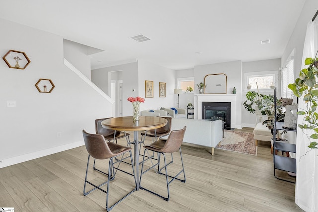 26 Shorncliffe Rd, Simpsonville, SC 29680 - dining space featuring visible vents, baseboards, light wood-style flooring, and a glass covered fireplace