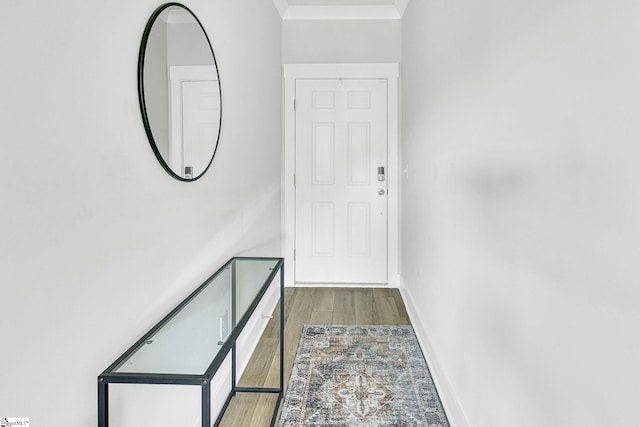 doorway to outside with crown molding and light hardwood / wood-style floors