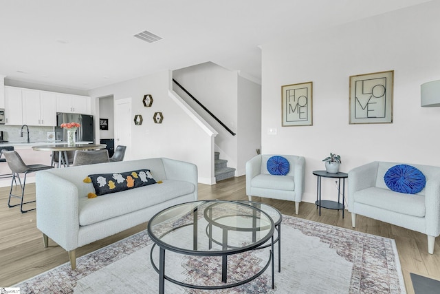 living room with sink and light hardwood / wood-style flooring