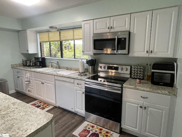 kitchen featuring a textured ceiling, white cabinetry, dark hardwood / wood-style floors, sink, and stainless steel appliances