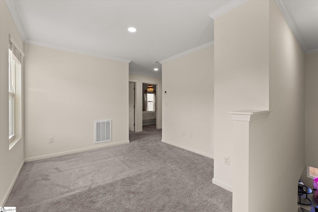 spare room with ornamental molding and light colored carpet