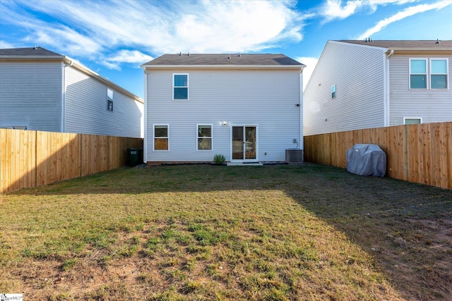 back of property with central air condition unit and a lawn