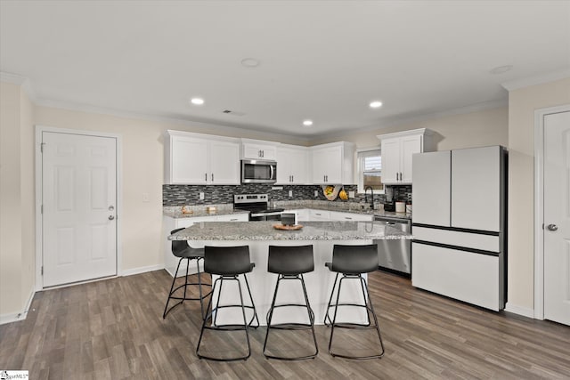 kitchen featuring a center island, dark wood-type flooring, appliances with stainless steel finishes, and white cabinets