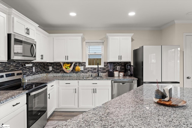 kitchen with white cabinetry, light stone countertops, appliances with stainless steel finishes, and sink