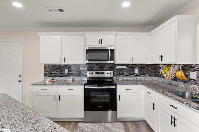 kitchen featuring decorative backsplash, appliances with stainless steel finishes, and white cabinets