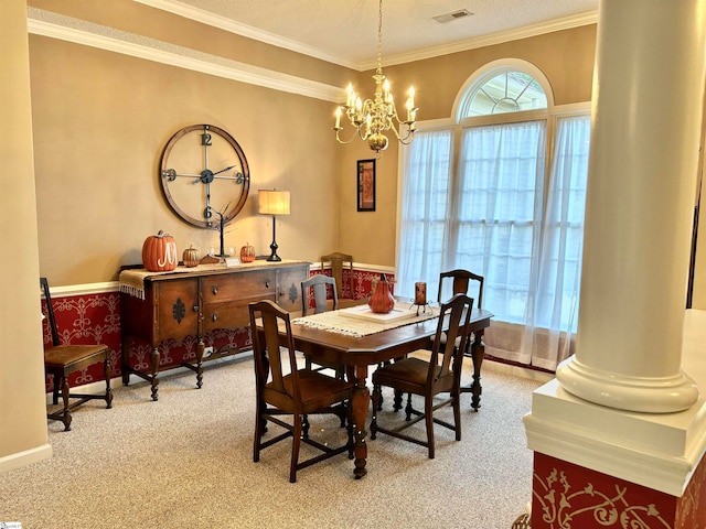 carpeted dining room featuring ornamental molding, a notable chandelier, a textured ceiling, and decorative columns