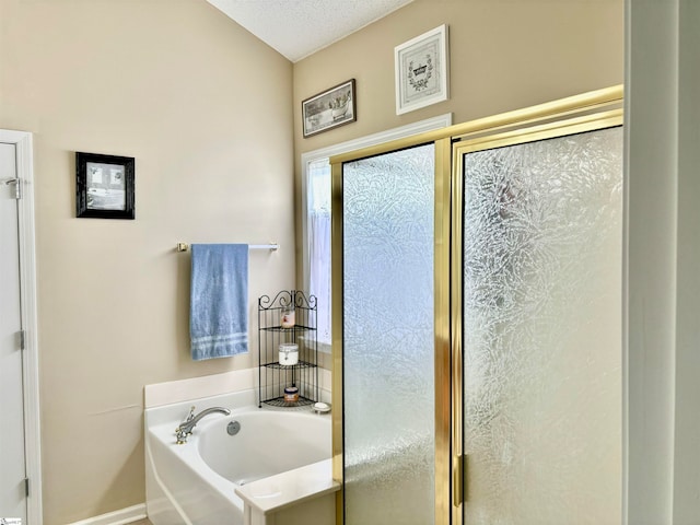 bathroom featuring separate shower and tub and a textured ceiling