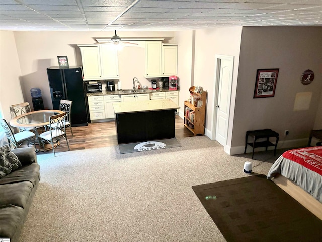 interior space with sink and black refrigerator with ice dispenser