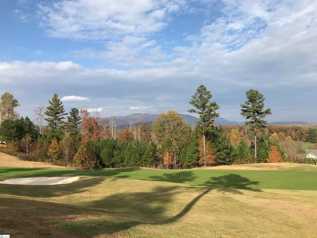 surrounding community with a mountain view and a lawn