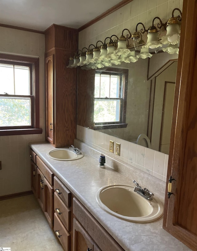 bathroom with vanity, ornamental molding, backsplash, and plenty of natural light