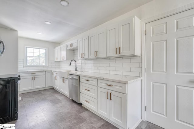 kitchen with sink, stainless steel dishwasher, white cabinets, light stone counters, and tasteful backsplash