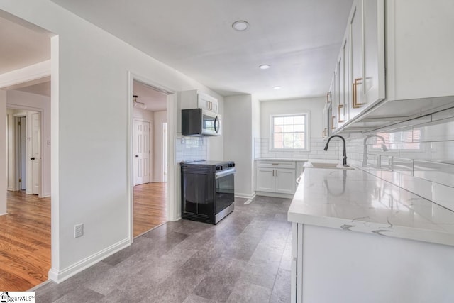 kitchen with appliances with stainless steel finishes, sink, white cabinets, and dark hardwood / wood-style floors