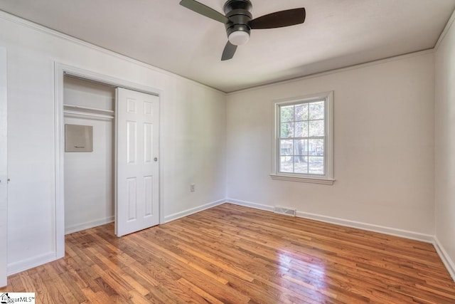 unfurnished bedroom with a closet, ceiling fan, ornamental molding, and light hardwood / wood-style floors