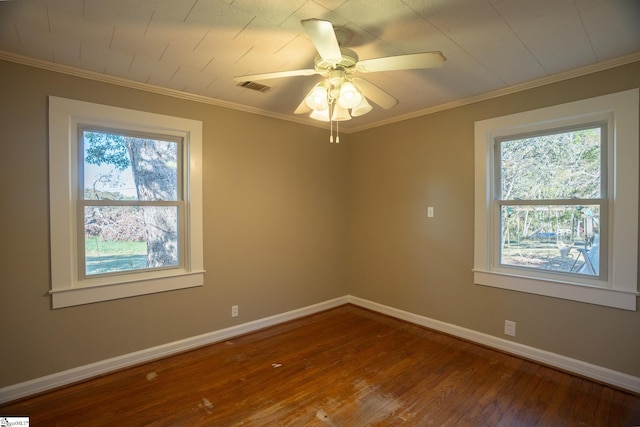 spare room with ceiling fan, a healthy amount of sunlight, wood-type flooring, and ornamental molding