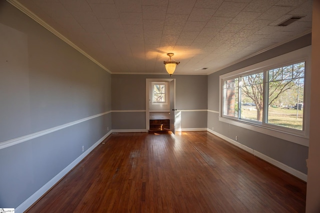 empty room featuring dark wood-type flooring and crown molding