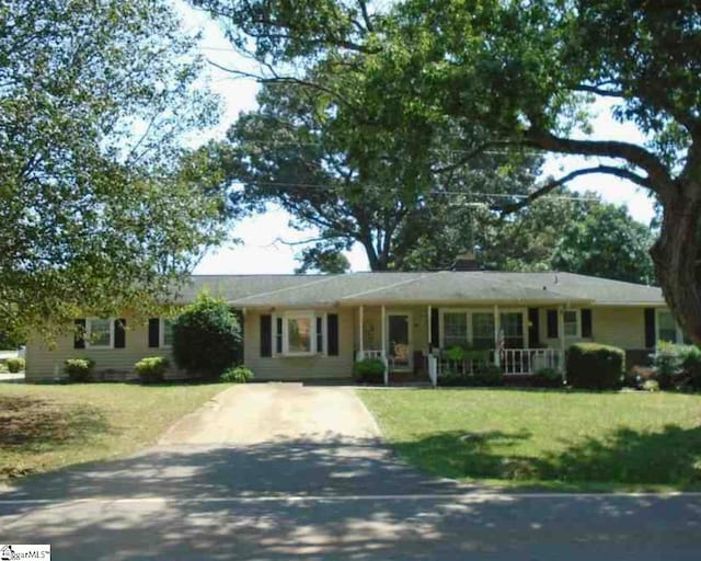 single story home with covered porch and a front yard